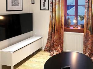 a living room with a flat screen tv and a table at Holiday home Idre VII in Idre