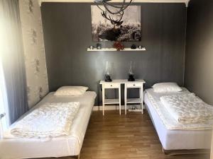 a bedroom with two beds and a table with a picture at Holiday home Idre VII in Idre