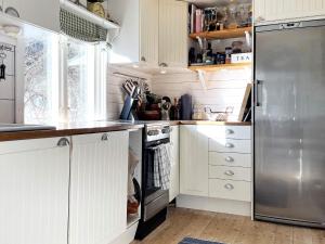 a kitchen with white cabinets and a stainless steel refrigerator at Holiday home Linköping II in Linköping