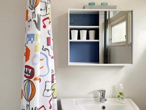 a bathroom with a sink and a mirror at Holiday home GRISSLEHAMN XIV in Grisslehamn