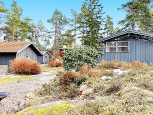 ein Haus mit einem blauen Haus und Bäumen in der Unterkunft Holiday home GRISSLEHAMN XIV in Grisslehamn