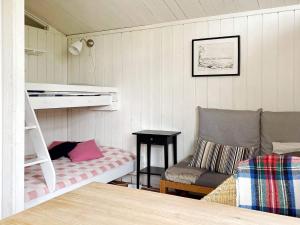 a small room with a bunk bed and a chair at Holiday home GRISSLEHAMN XIV in Grisslehamn