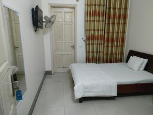 um pequeno quarto com uma cama e uma porta em khach san viet uc em Vinh