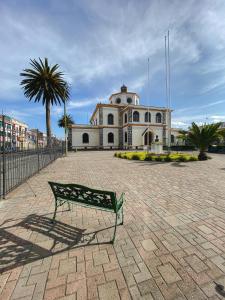 a bench sitting in front of a building at Golden Rest Ecuador in Latacunga