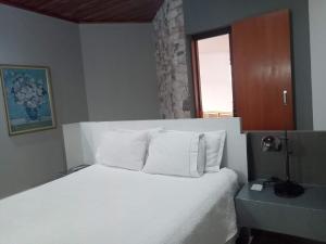 a bedroom with a bed with white sheets and a window at CORTESE HOTEL in Tatuí +30 photos
