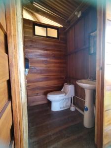 a small bathroom with a toilet and a sink at Cabaña Vistas Paraíso in La Suiza