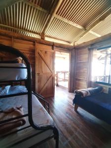 a room with a bunk bed and a window and a door at Cabaña Vistas Paraíso in La Suiza