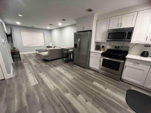 a kitchen with white cabinets and stainless steel appliances at The Lovely Suite - 1BR close to NYC in Paterson