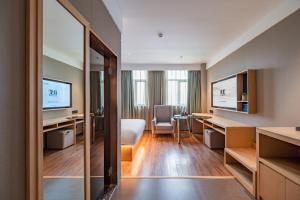 une chambre d'hôtel avec une chambre et un salon dans l'établissement True Go Hotel - Beijing Asian Games Village National Convention Center, à Pékin