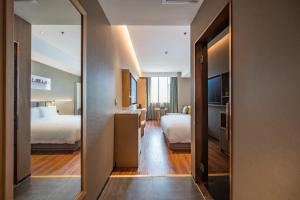 Cette chambre comprend 2 lits et un miroir. dans l'établissement True Go Hotel - Beijing Asian Games Village National Convention Center, à Pékin