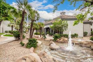 een fontein voor een huis met palmbomen bij Elegant Scottsdale Condo - Newly Refurbished Ground Floor Unit in Scottsdale
