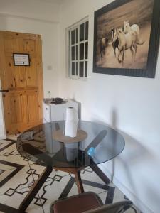 a room with a glass table and a picture of horses at Exquisite Home away from Home! in Kingstown