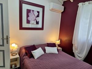 sypialnia z fioletowym łóżkiem z 2 poduszkami w obiekcie Villa Almeida à 500m de la plage w mieście Courcelles Sucrerie