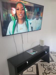 a tv with a picture of a woman on it at Exquisite Home away from Home! in Kingstown