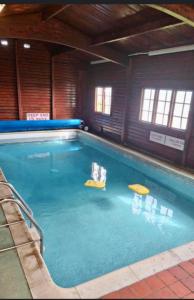 a large swimming pool with blue water in a building at Bay 1 in Kirkcolm