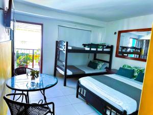 a bedroom with a bed and a table and bunk beds at Aparta Hotel Bacano Historico in Santa Marta