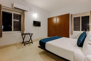 a bedroom with a large white bed and windows at OYO SilverKey Oyo Silverkey ,near RTO office kondapur in Kondapur