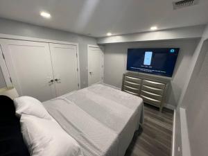 1 dormitorio con 1 cama y TV de pantalla plana en The Charming Suite - 1BR close to NYC, en Paterson