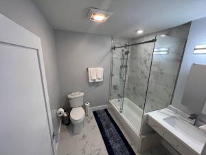 a bathroom with a shower and a toilet and a sink at The Charming Suite - 1BR close to NYC in Paterson