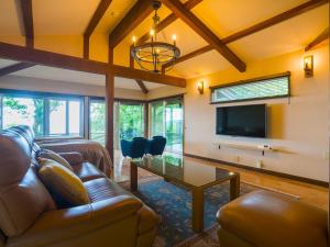 a living room with a couch and a flat screen tv at Spagreenness in Kokonoe