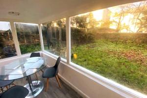 een kamer met een raam met een glazen tafel en stoelen bij Gravesend - 1 bedroom Apartment in Kent