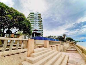 een trap naar het strand met een gebouw bij Happy Life Seaview @PalmPavillion in Hua Hin