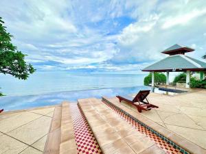 a bench next to a pool with the water at Happy Life Seaview @PalmPavillion in Hua Hin