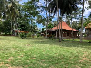 uma casa num quintal com palmeiras em Puri Sanghyang em Batukaras