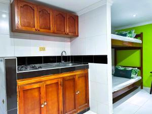 a kitchen with wooden cabinets and a sink at Aparta Hotel Bacano Historico in Santa Marta
