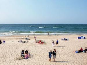 a group of people on a beach near the ocean at New holiday apartment in Mrze yno in Mrzeżyno