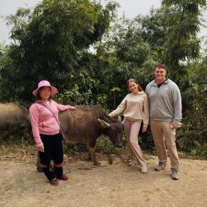 a group of people standing next to a cow at Muong Hoa Hmong Homestay in Sa Pa