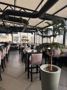 un restaurante con mesas y sillas y una maceta en POST Hotel Amman, en Amán