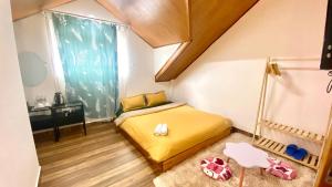 Un pequeño dormitorio con una cama amarilla y una ventana en Ruby Peace Hotel en Khu Chi Lăng