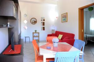 sala de estar con mesa y sofá rojo en Le Residenze Salentine - Case Vacanza in Lecce, en Lecce