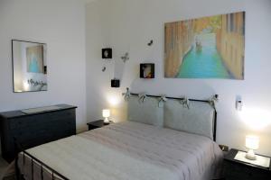 1 dormitorio con 1 cama y una pintura en la pared en Le Residenze Salentine - Case Vacanza in Lecce, en Lecce