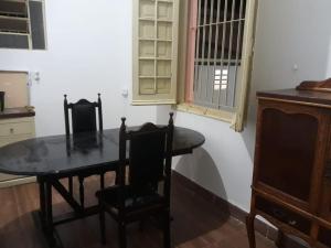 uma sala de jantar com uma mesa e duas cadeiras em Casa Patrimônio Histórico - Centro de Uberaba em Uberaba