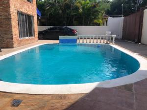 a pool in a yard with a car parked next to it at Casa Amplia con Piscina in San Felipe de Puerto Plata