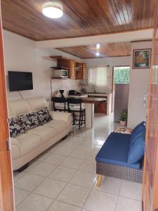a living room with a couch and a kitchen at Departamento Ángeles del Arenal #1 in Fortuna +79 photos