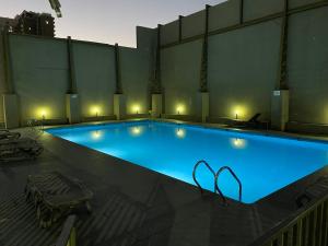 una gran piscina azul con luces encendidas en Amoblados MyK Metro Irarrazabal en Santiago