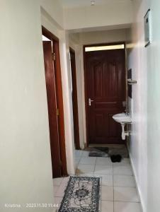 uma casa de banho com um WC, um lavatório e uma porta em Nairobi Airbnb em Nairobi