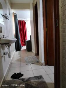 uma casa de banho com um lavatório e um lavatório em Nairobi Airbnb em Nairobi