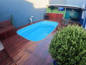 Baru Bonito - Suítes في بونيتو: يوجد حوض استحمام أزرق كبير على سطح خشبي