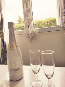 butelkę szampana i dwa kieliszki na stole w obiekcie Maison Time Break Jacuzzi - 4 étoiles w mieście Thonon-les-Bains