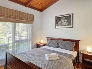 une chambre avec un lit avec deux serviettes dessus dans l'établissement Banksia Cottage, à Halls Gap
