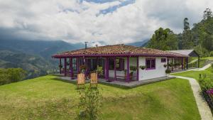 a small purple and white house on a hill at La Casa en las Nubes in Salento +58 photos