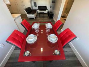 una mesa roja con sillas rojas y platos en ella en The Classy Suite - 2BR with Free Parking, en Paterson