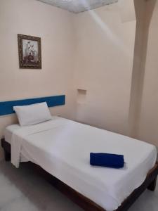 Una cama blanca con una caja azul encima. en Mansion Giahn Bed & Breakfast, en Cancún