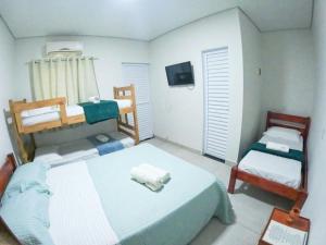 a bedroom with two bunk beds and a tv at Baru Bonito - Suítes in Bonito
