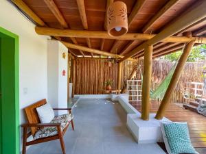 une terrasse avec un plafond en bois et des chaises sur une terrasse couverte. dans l'établissement Locanda Ariramba, à Santa Cruz Cabrália