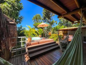 een terras met een hangmat en een zwembad bij Locanda Ariramba in Santa Cruz Cabrália